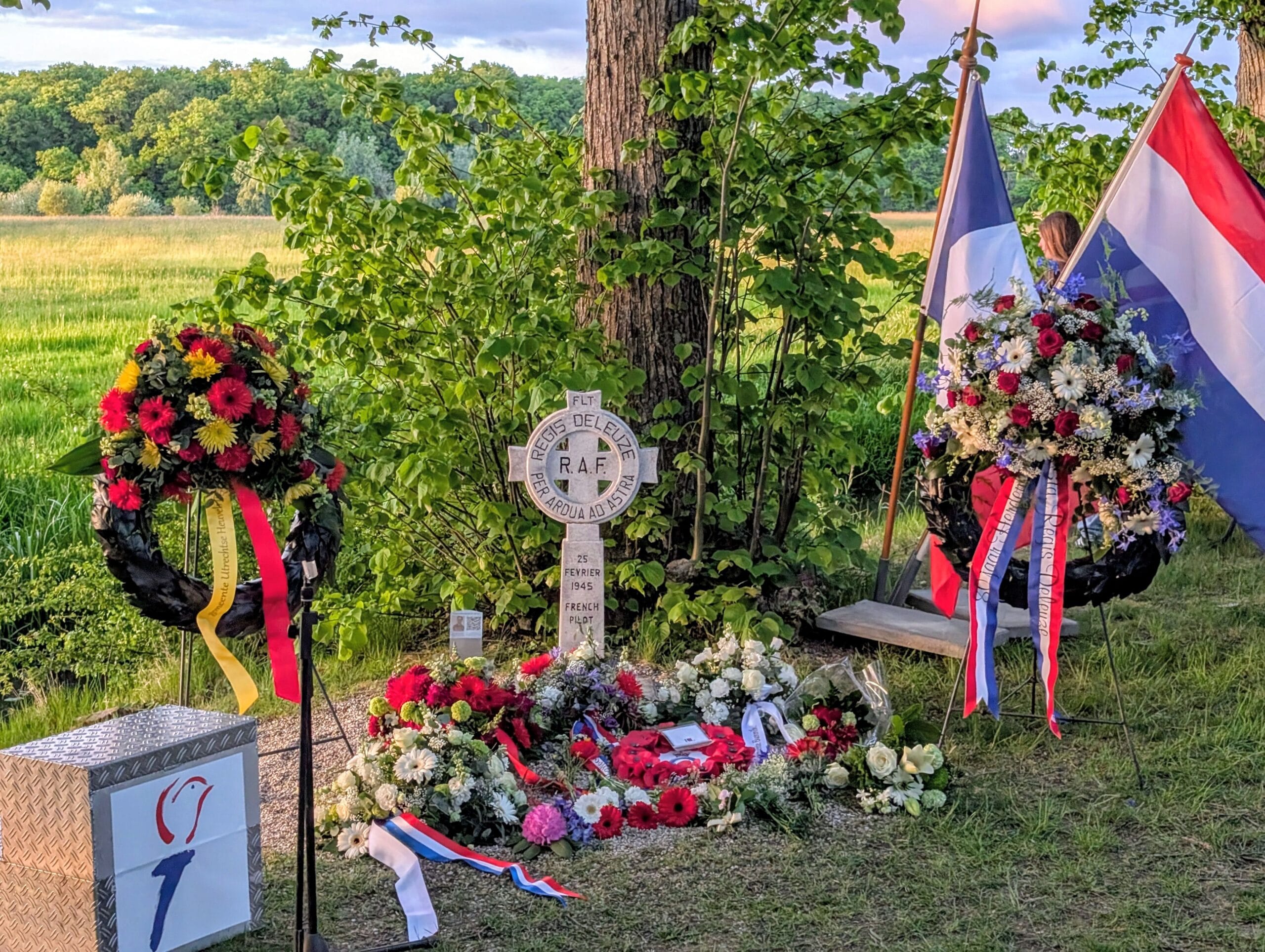 Monument voor Régis-Charles Deleuze in Werkhoven, met bloemen voor het monument en de Nederlandse, Franse en Engelse vlag ernaast in beeld.